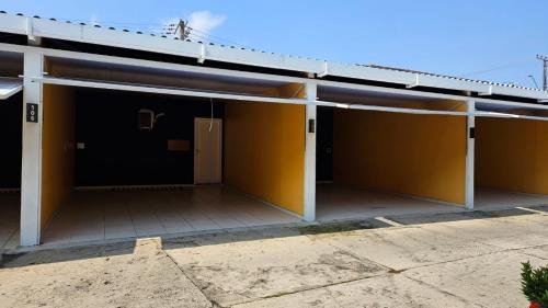ein Haus mit gelben Wänden und einer Tür in der Unterkunft Pousada Ponta Negra in Manaus