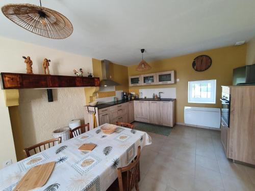 une salle à manger avec une table et une cuisine dans l'établissement le Moulin de la Raterie, à Charensat