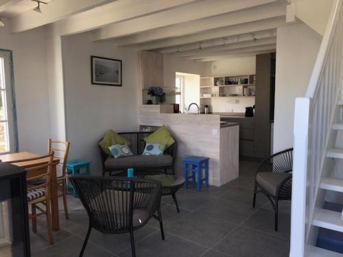 Il comprend un salon avec des chaises et une table ainsi qu'une cuisine. dans l'établissement Maison Locmaria, 3 pièces, 4 personnes - FR-1-418-91, à Locmaria