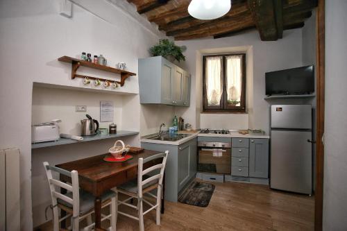 a small kitchen with a table and a refrigerator at Il Terrazzino in Cetona