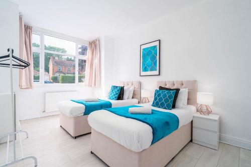 a bedroom with two beds and a window at Large 5 Bedroom Edgbaston Townhouse - 10 Guests - Free WIFI, Netflix & On street Parking - 974P in Birmingham