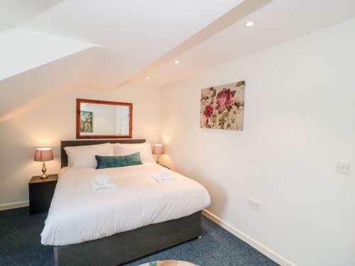 a bedroom with a bed and a mirror on the wall at Emminster in Weymouth