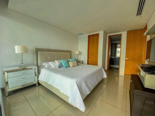 a bedroom with a bed and a dresser with a night stand at hyatt(H2)luxury in Cartagena de Indias