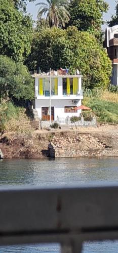 a white house on the shore of a body of water at Esmerada in Aswan