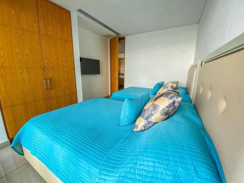 a bedroom with a blue bed with two pillows at hyatt(H2)luxury in Cartagena de Indias