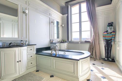 a bathroom with a large sink and a mannequin in a window at Duplex d'exception face Hippodrome avec Jardin in Chantilly