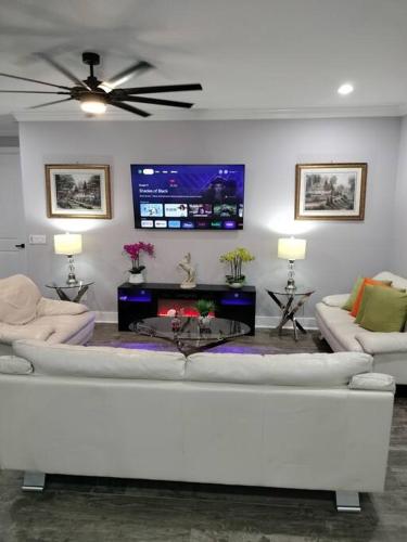 a living room with a white couch and a tv at Villa White Rock in Tampa in Tampa