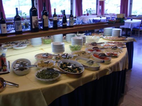 a table with plates of food and bottles of wine at Hotel Rodes in Ortisei