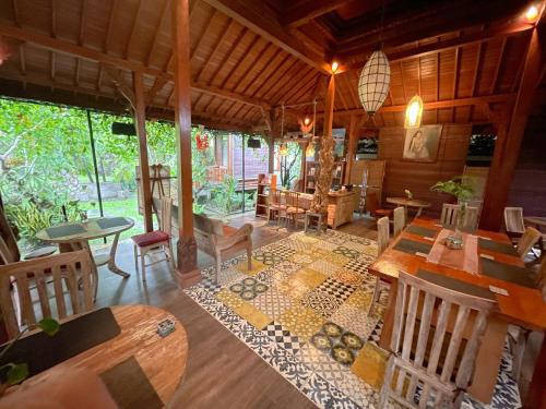 TampaksiringにあるMirah Guest Houseのリビングルーム(木製のテーブル、椅子付)