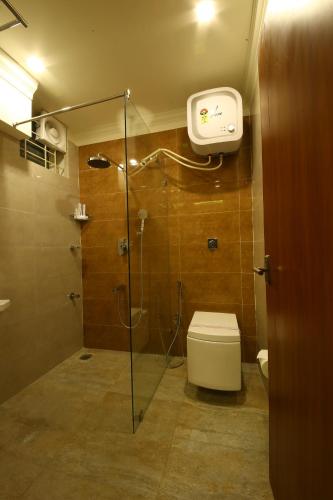 a bathroom with a glass shower with a toilet at Royal Stay in Bengaluru