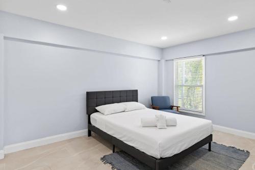 ein weißes Schlafzimmer mit einem Bett und einem blauen Stuhl in der Unterkunft Upgraded Ground Floor Residence on Buttonwood Ln w Bikes in Sanibel