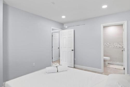 a white bathroom with a toilet and a mirror at Upgraded Ground Floor Residence on Buttonwood Ln w Bikes in Sanibel