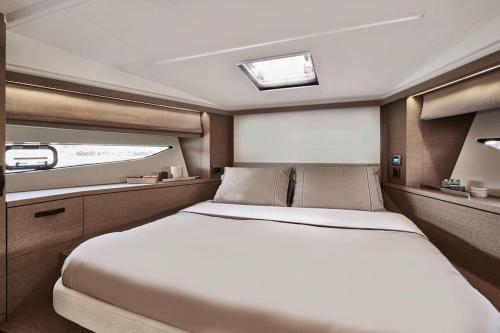 ein großes weißes Bett in einem Zimmer mit Fenster in der Unterkunft Il Bello - Cannes, Vieux-Port in Cannes