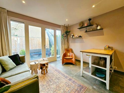 ein Wohnzimmer mit einem Sofa und einem Tisch in der Unterkunft Zandvoort at Home I Free parking & Airco in Zandvoort