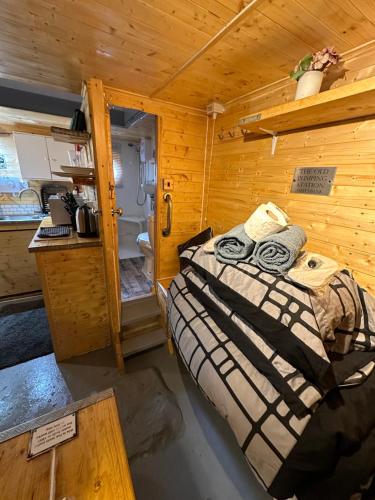 sypialnia z łóżkiem w drewnianym pokoju w obiekcie The old water pumping station quirky underground hobbit house w mieście Penzance