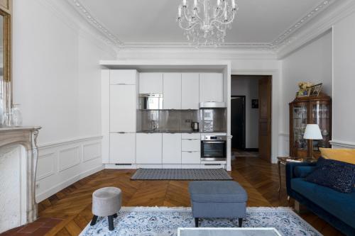 - un salon avec des murs blancs et un canapé bleu dans l'établissement Veeve - Porcelain Pelouse, à Paris