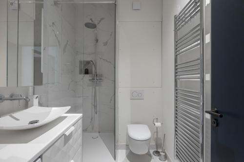 une salle de bain avec une douche, des toilettes et un lavabo dans l'établissement Veeve - Porcelain Pelouse, à Paris