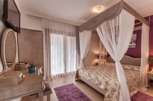 a bedroom with a canopy bed and a mirror at Mara Bahçe Alacati in Alaçatı