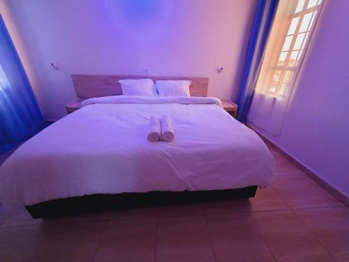 a bedroom with a bed with two slippers on it at COMFORT E SUITES in Nairobi