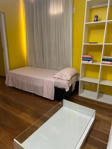 a small room with a bed and a book shelf at Apartamento Avenida Atlântica in Rio de Janeiro