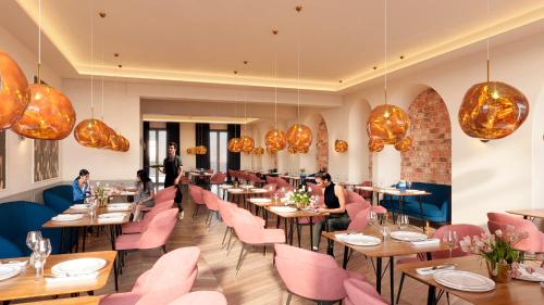 ein Restaurant mit rosafarbenen Stühlen und Tischen und Sitzgelegenheiten in der Unterkunft Neueröffnung 2024 Grand Hotel Nautimar in Büsum