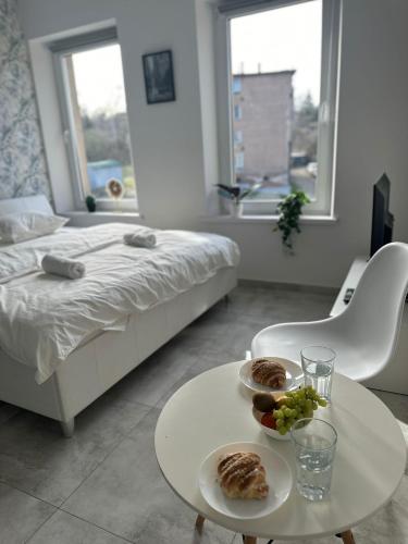 una habitación con una cama y una mesa con comida. en Kawalerka w Górach, en Wałbrzych