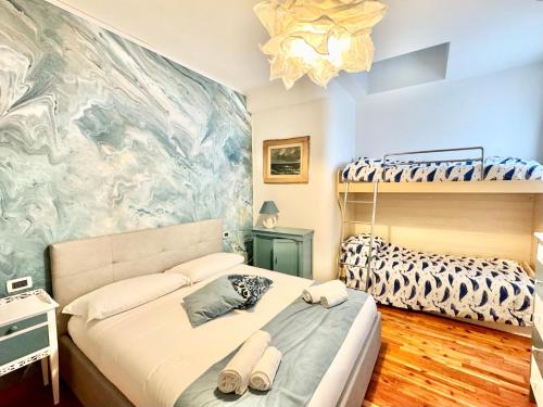 a bedroom with two bunk beds and a mural at Hostdomus - Le Vigne sul Mare in Pietra Ligure