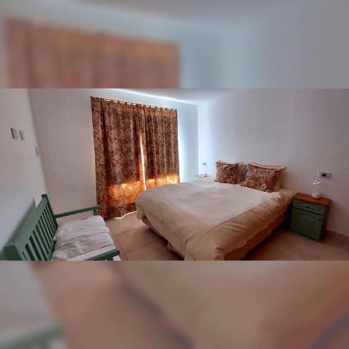 a bedroom with a bed and a window at Corinto Tempo in Esquel