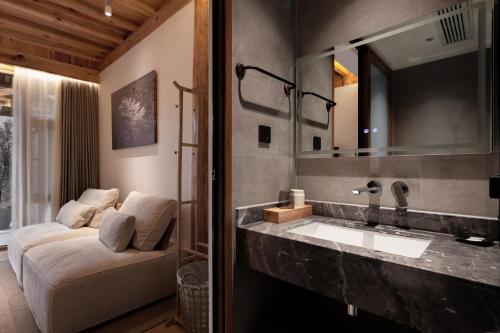 a bathroom with a sink and a large mirror at Humble abode of happiness - Mountain View Wabi-sabi Lodge in Lijiang