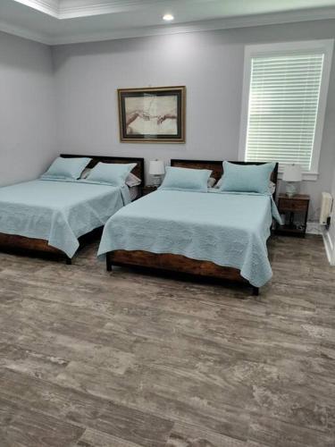 two beds in a room with white walls at Villa White Rock in Tampa in Tampa