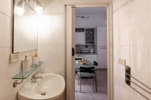 een badkamer met een wastafel, een spiegel en een tafel bij Santa Maria Maggiore Apartment in Barletta