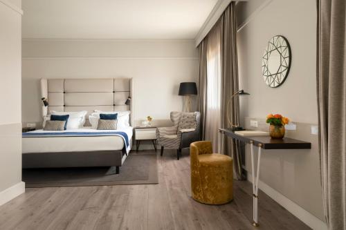 a hotel room with a bed and a desk at Cerretani Hotel Firenze - MGallery Collection in Florence