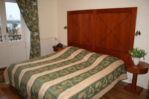a bedroom with a bed with a large wooden headboard at Stadshotellet Sölvesborg in Sölvesborg