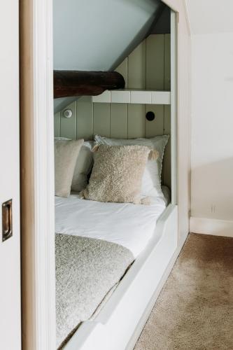 a white bed with pillows in a room at Het Hart Van Alem in Alem