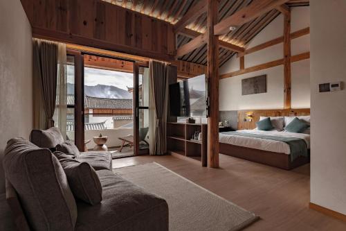 a bedroom with a bed and a tv and a couch at Humble abode of happiness - Mountain View Wabi-sabi Lodge in Lijiang