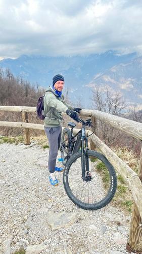 a man standing next to a bike on a fence at OLD SQUARE HOUSE - HIŠA NA STAREM TRGU in Tolmin