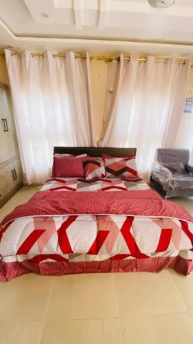 - une chambre dotée d'un lit rouge et blanc avec des rideaux dans l'établissement VIRGINISLANDGH, à Beachtown