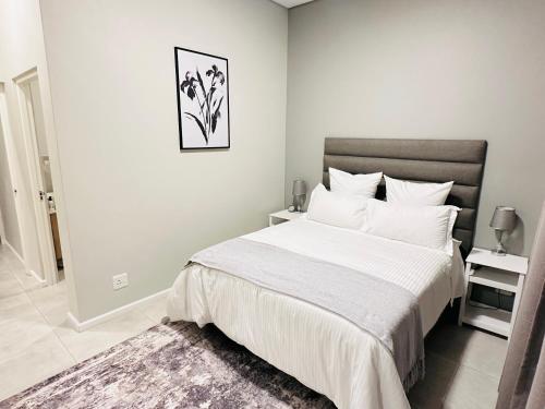 Dormitorio blanco con cama grande y alfombra en Shamah en Pretoria