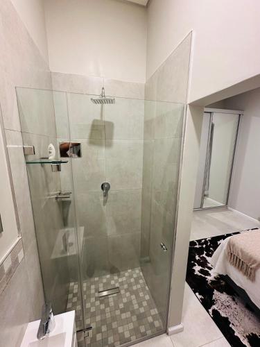 a shower with a glass door in a bathroom at Shamah in Pretoria