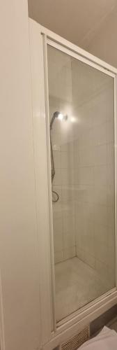 une douche avec une porte vitrée dans une salle de bain dans l'établissement HOTEL ABOUKIR, à Paris