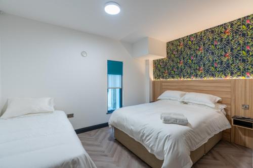 1 dormitorio con 2 camas y un mural en la pared en Hotel No.9, en Derry Londonderry