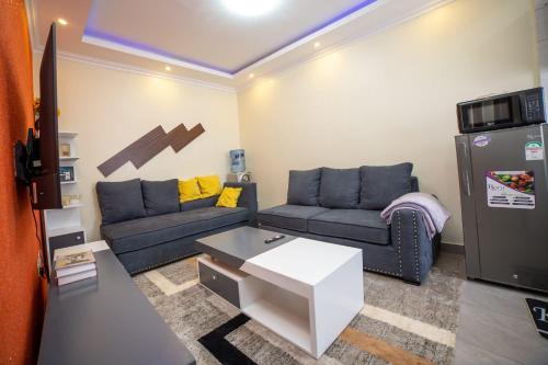 ein Wohnzimmer mit einem Sofa und einem Kühlschrank in der Unterkunft Tegera Homes in Kericho