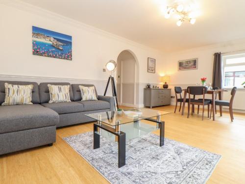 a living room with a couch and a table at Swans Nest in Falmouth