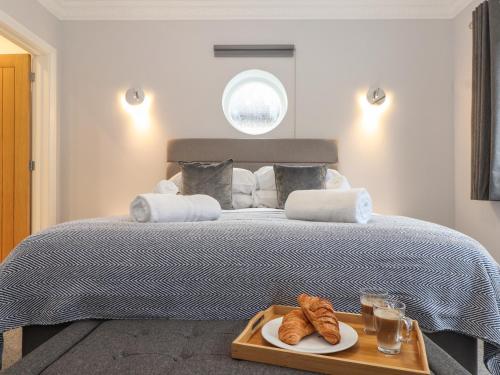 a bedroom with a bed with a tray of croissants at Swans Nest in Falmouth