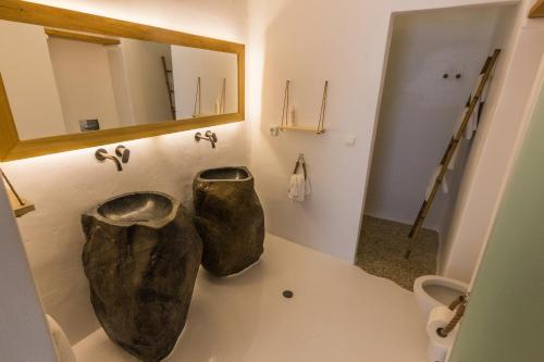 a bathroom with two toilets and a mirror on the wall at SALT SUITES MILOS in Pollonia