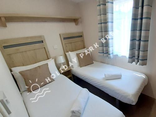 a small room with two beds and a window at Seagull Cove - 3bed at Seal Bay Resort in Selsey in Selsey