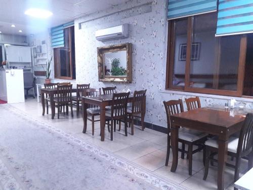 restauracja z drewnianymi stołami i krzesłami w pokoju w obiekcie YAŞAR OTEL w mieście Mersin