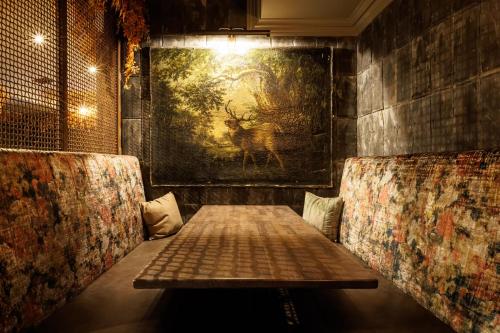 a table and two chairs in a room with a painting at The Hardiman in Galway