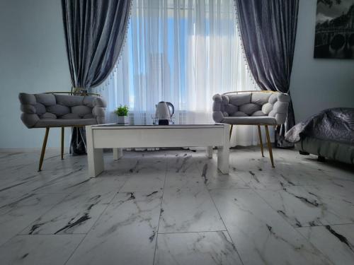 sala de estar con mesa blanca y 2 sillas en Київські Ночі, en Kiev