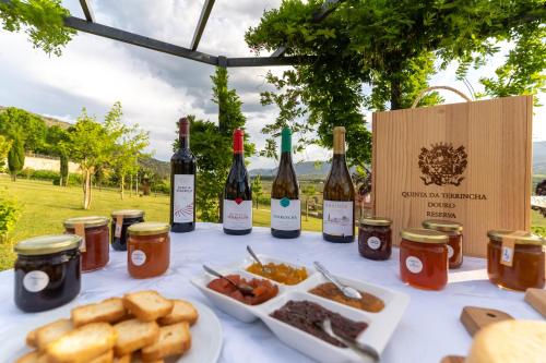 a table with bottles of wine and a plate of food at Quinta da Terrincha in Torre de Moncorvo